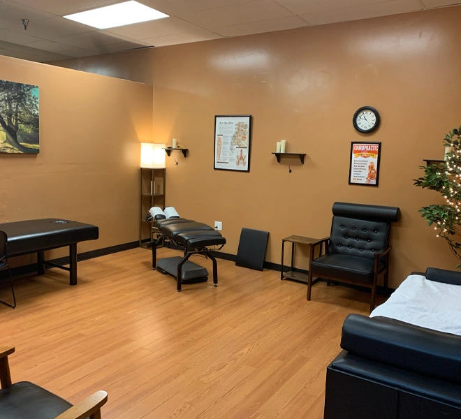 A clean chiropractic room featuring wood‑tone flooring