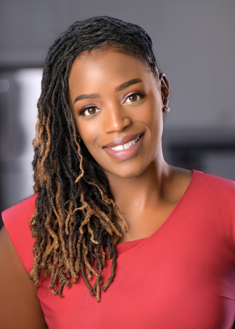 Person with long, textured, partially highlighted locs wearing a sleeveless red top